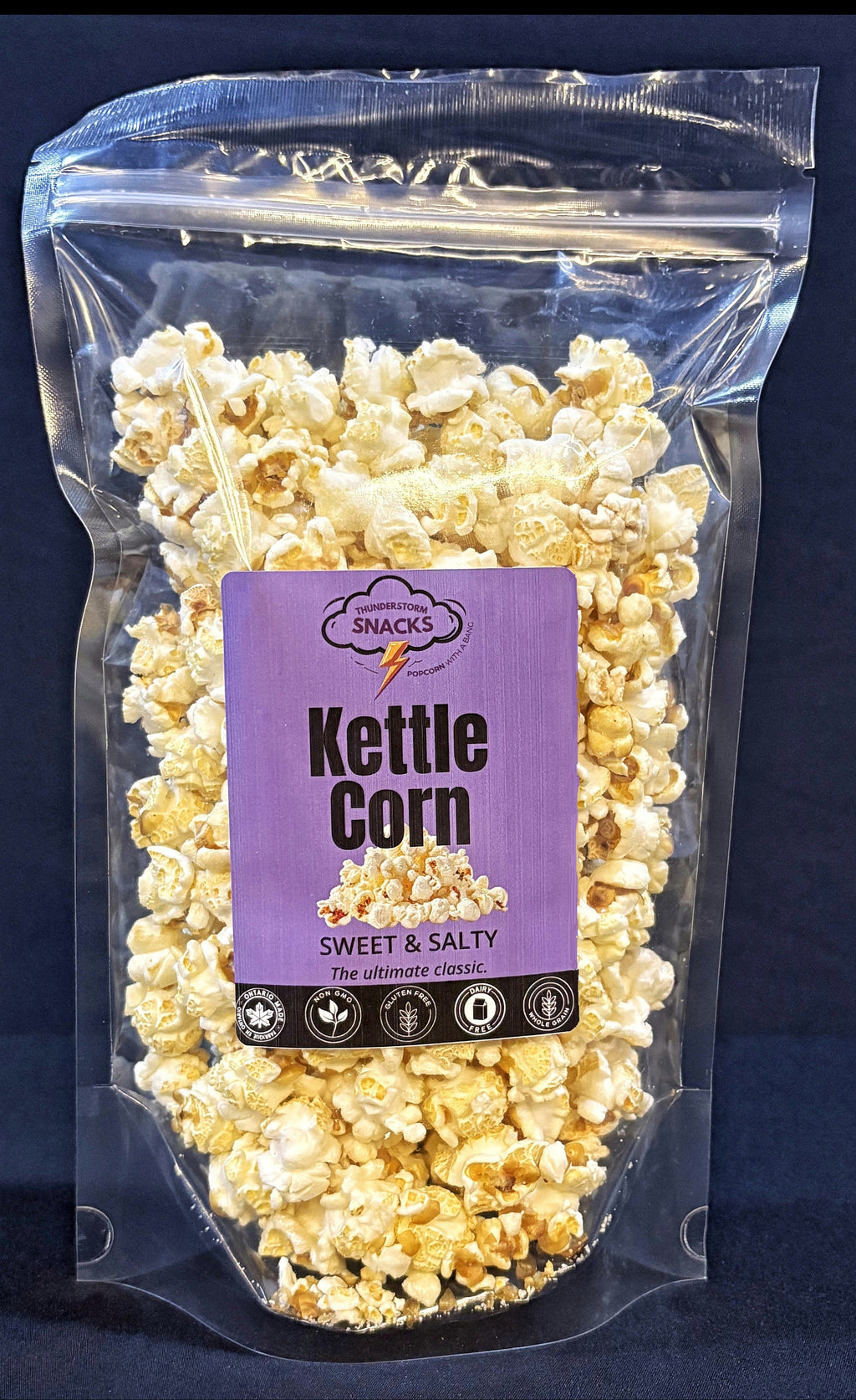 Packaged kettle corn with a purple label on a dark blue background