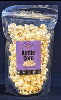 Packaged kettle corn with a purple label on a dark blue background