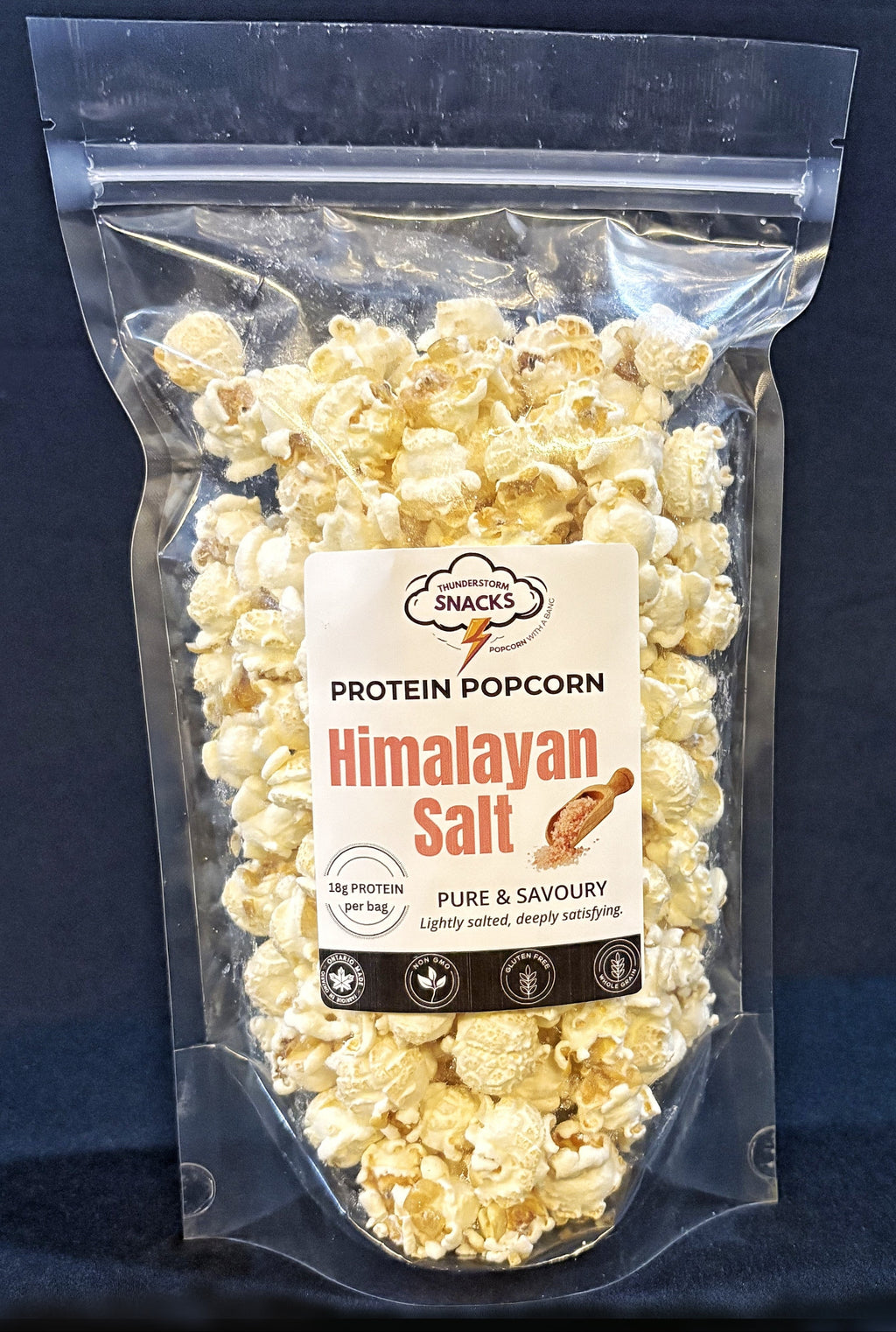 Protein popcorn with Himalayan salt flavor packaging on a dark background